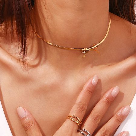 Model showcasing the layered look of the gold choker necklace paired with matching rings.