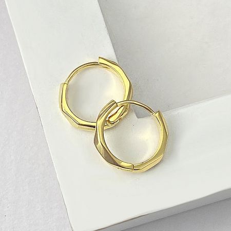 Close-up of the gold-plated octagon huggie hoop earring.