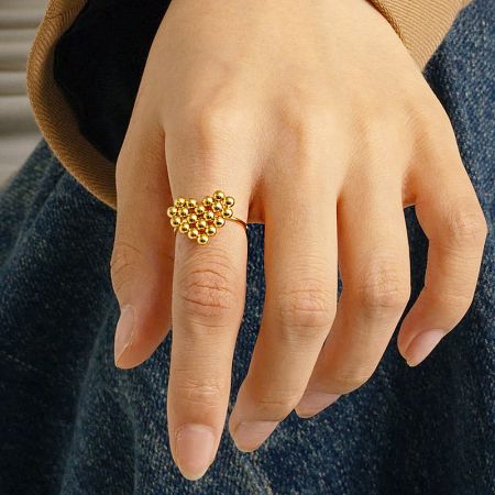 Full view of the gold bead cluster adjustable ring on a neutral background.