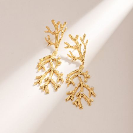 Detailed view of the gold-plated coral earrings with pearl accents.
