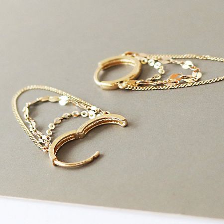 Feature image of the crescent-shaped hoop earrings with delicate chain dangles.