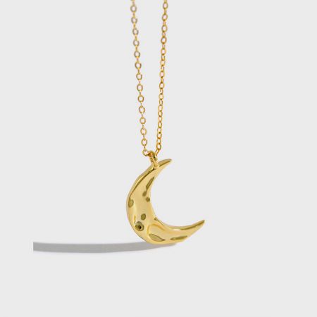 Close-up of the 18K gold plated crescent moon pendant, highlighting its minimalist design.
