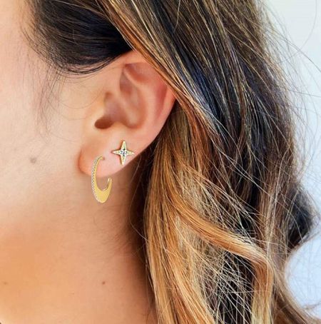 Close-up of a model wearing the gold crescent moon and star hoop earrings to showcase the style.