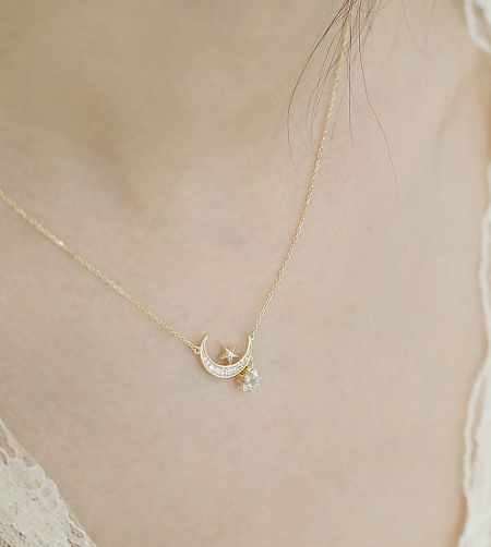 Collar de Luna y Estrella de Plata Esterlina 925 - Un primer plano del collar de luna y estrella de plata esterlina 925, que muestra el detallado colgante de luna creciente y estrella chapado en oro, adornado con brillantes piedras de circonio cúbico.