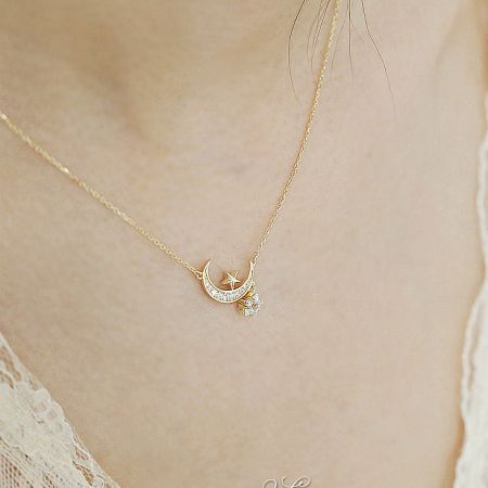 Detailed shot of the gold-plated star and moon pendant, emphasizing the brilliant zircon stones.