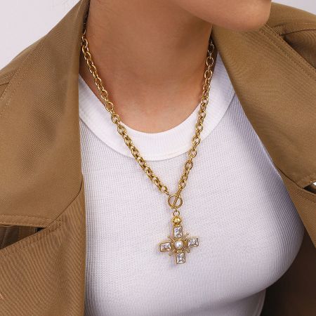Detailed view of the gold cross pendant necklace with purple crystals, showing its size and stainless steel material.