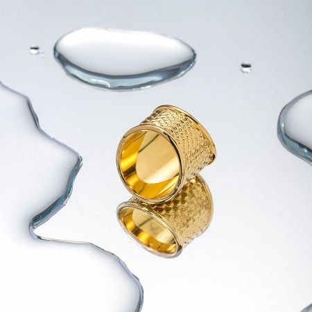 Detailed view of the textured surface of the stainless steel gold ring.