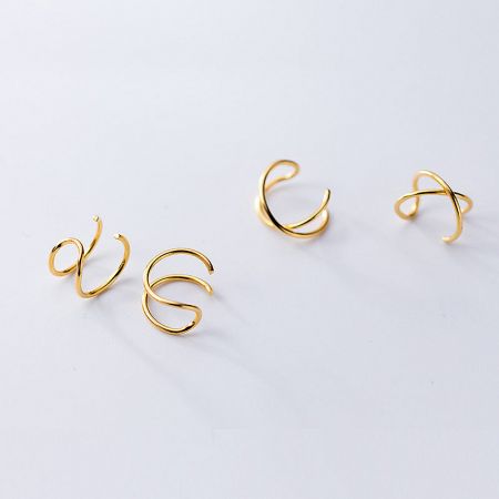 A set of four gold curved cuff earrings, showcasing the product variety.