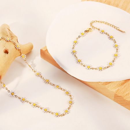 Elegant gold chain bracelet showcasing delicate white daisy charms.