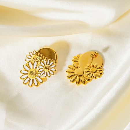 Detailed shot of the gold daisy earrings with white enamel petals.