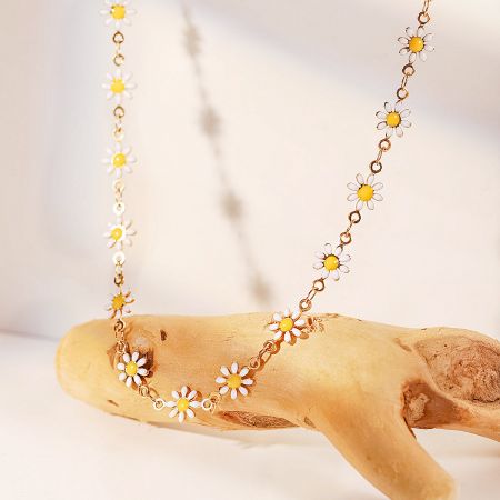 Elegant white daisy charm necklace displayed on natural driftwood.