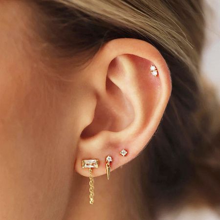 3pcs Set Tiny 925 Sterling Silver Piercing Ear Studs (5 Sets) - A close-up view on a woman's ear showcasing a curated set of three tiny 925 sterling silver piercing ear studs with minimalist designs.