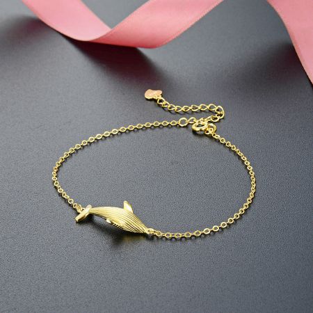 A similar gold bracelet featuring a dolphin charm.