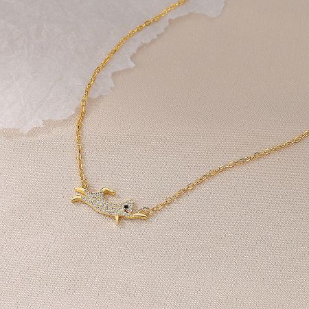 Close-up of the gold-finished dog pendant necklace, showcasing its warm tone and sparkling gemstones.