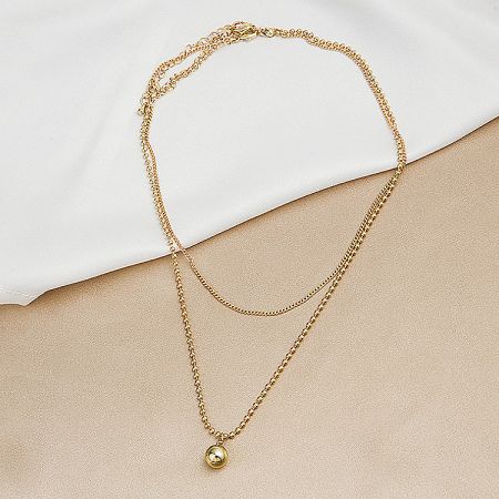 Detailed view of the gold double-layered necklace with its small spherical pendant.