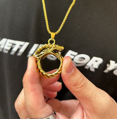 Detailed shot of the gold dragon pendant necklace, showcasing its polished finish and craftsmanship.
