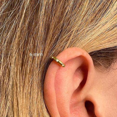 Close-up of a 6mm gold hoop earring worn as a cartilage piercing.