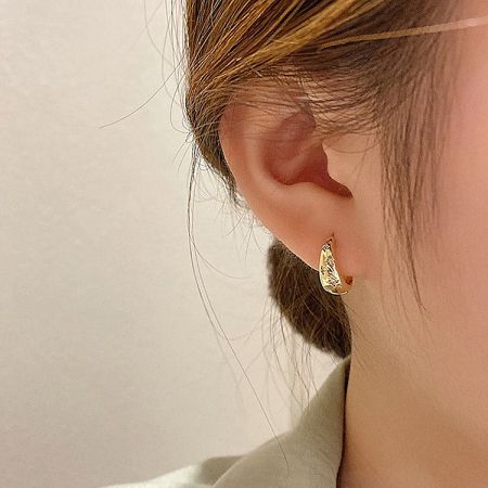Side profile of a model wearing the 925 silver gold star zirconia hoop earring.