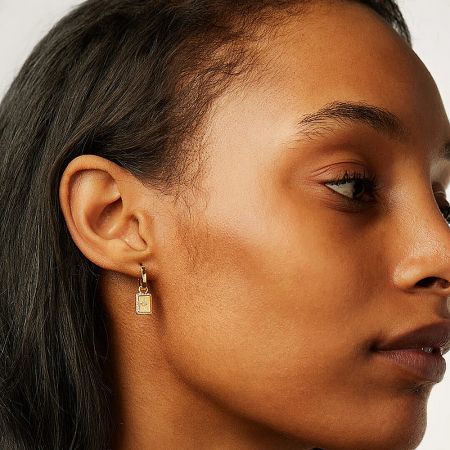 Close-up view of a woman's ear wearing the gold celestial square charm dangle earring.