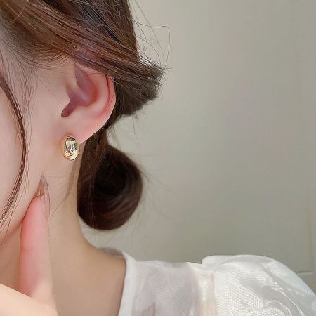 Detailed shot of the gold variant of the French small bean stud earring being worn.