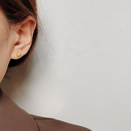 A close-up shot of the mini heart stud earring on an ear.