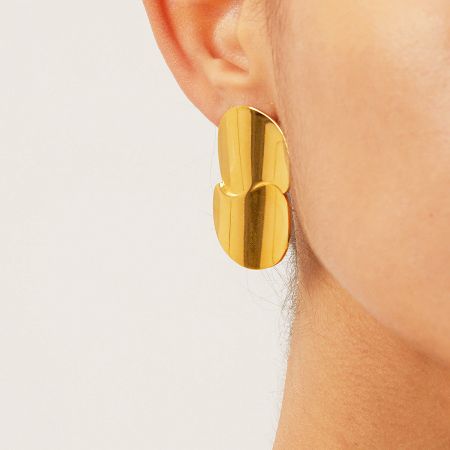 Close-up of a model wearing the gold chunky geometric disc earring.