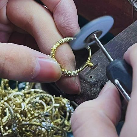 Artisan performing fine polishing on a gold earring