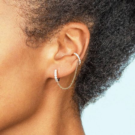 Model showcasing the gold double hoop chain cuff earring, highlighting its elegant drape and fit on the ear.