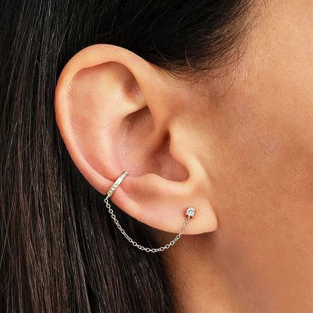 Close-up view of the gold zircon chain link cuff earring on an ear.