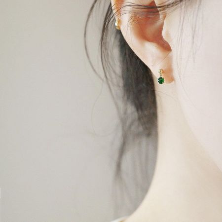 Detailed shot of a single tiny jade earring, showing the quality craftsmanship of the 925 sterling silver setting.