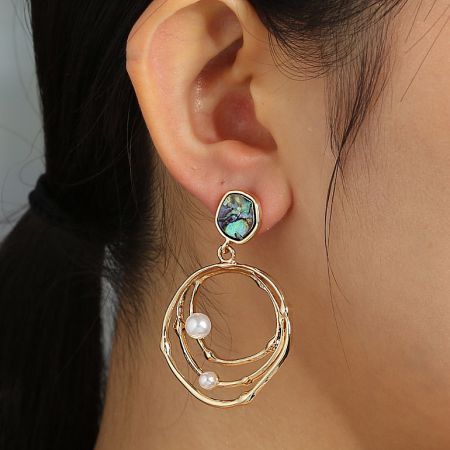 Side profile of the delicate gold earring, showing the arrangement of the opal-like stone and classic pearls.
