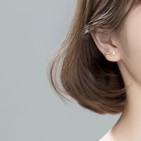 Side profile of a model wearing the elegant gold and pearl earring.