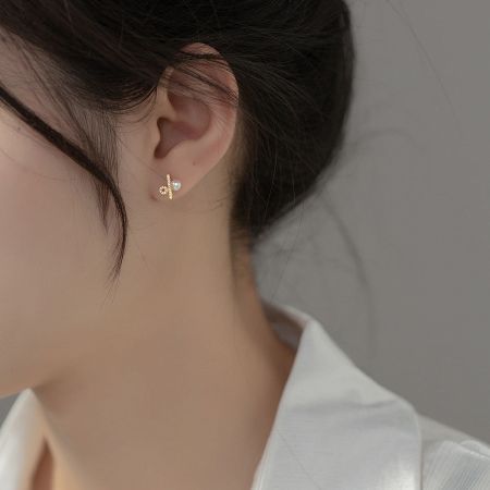 Close-up of a gold variant of the pearl stud earring, showcasing the bar and pearl design.