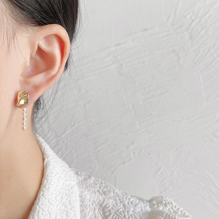 Model wearing the gold-plated baroque pearl drop earring.