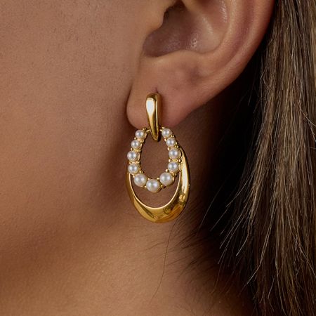Detailed close-up of a PVD gold-plated earring, showing the fine craftsmanship of the pearl setting.