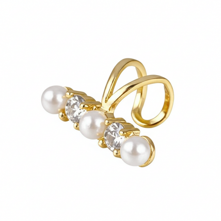Close-up of a gold non-pierced ear cuff with a pearl and clear cubic zirconia stones.