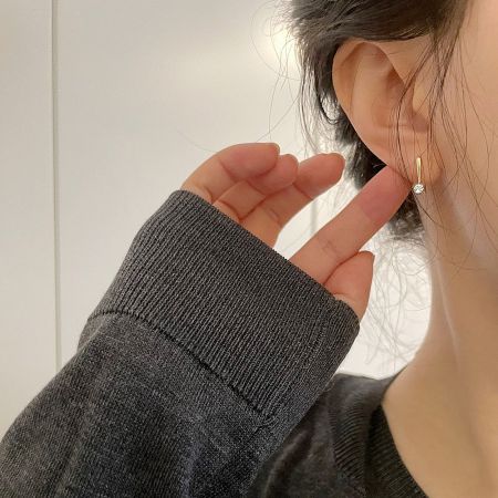 Model wearing the gold zircon threader earring to show scale and style.