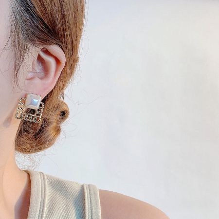 Close-up of a woman wearing a gold-plated pearl stud earring, showcasing its elegant French style.