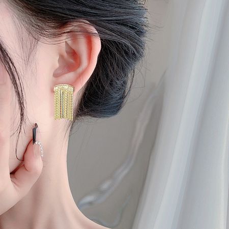 A model showcasing the elegant gold waterfall tassel drop earring.