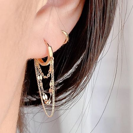 Macro shot highlighting the fine craftsmanship of the gold dangle earrings.