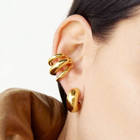 Detailed close-up of the gold geometric three-layer ear cuff.
