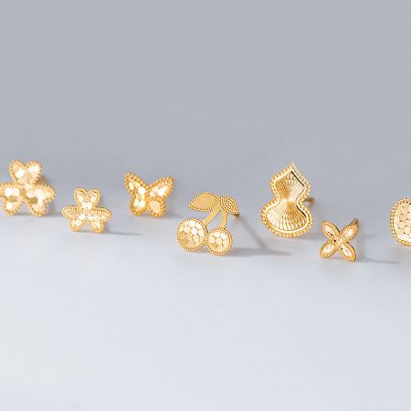 Wholesale 925 Sterling Silver Laser-Cut Stud Earrings Set (5 Pairs) - A collection of five pairs of wholesale 925 sterling silver laser-cut stud earrings in gold, featuring flower, butterfly, heart, cherry, and gourd designs, arranged on a white background.