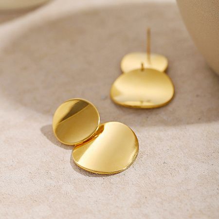 A pair of contemporary gold-finished stainless steel earrings against a neutral backdrop.