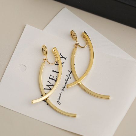 Close-up view of the gold-plated wire cross clip earrings, highlighting the intricate design.