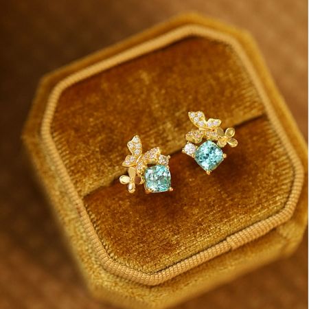 The blue gemstone butterfly earrings presented in a luxurious velvet jewelry box.
