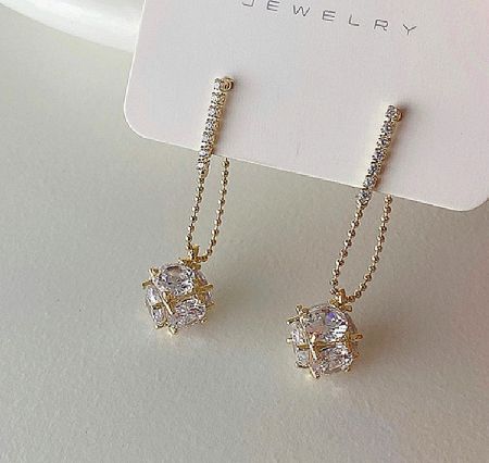 A pair of CZ Dice Drop Earrings displayed on a jewelry card, highlighting the gold plating and cubic zirconia details.