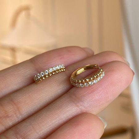 Wholesale 925 Sterling Silver 18k Gold Plated CZ Beaded Huggie Hoops (Set of 5) - A close-up view of a pair of 18k gold plated 925 sterling silver huggie hoop earrings, featuring a row of brilliant clear cubic zirconia gemstones.