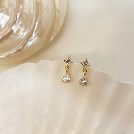 The water drop crystal earrings elegantly displayed on a seashell, emphasizing their sophisticated and nature-inspired design.