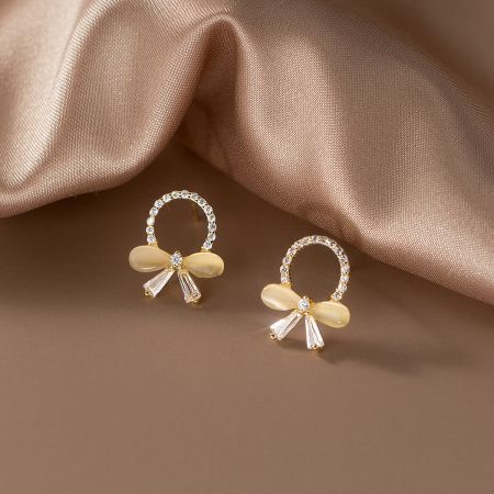 Another angle of the gold butterfly knot earrings highlighting the intricate stone setting.