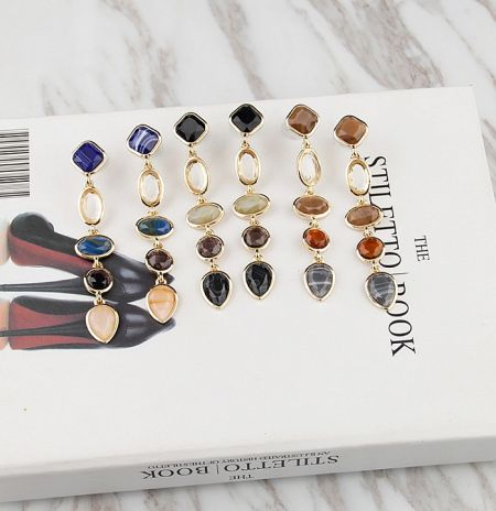Lifestyle shot of the colorful resin earrings displayed on a stylish book.